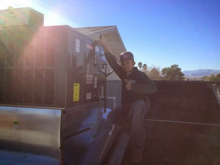 HVAC technician performing Boiler Repair on a rooftop unit in Goshen